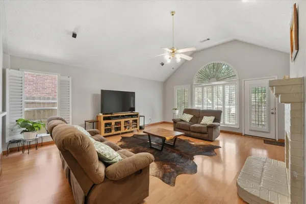 a living room with furniture ceiling fan and a flat screen tv
