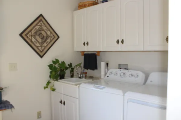 a view of a hallway with front door wooden floor and cabinet