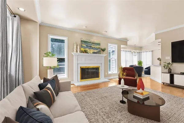 a living room with furniture floor to ceiling window and a flat screen tv