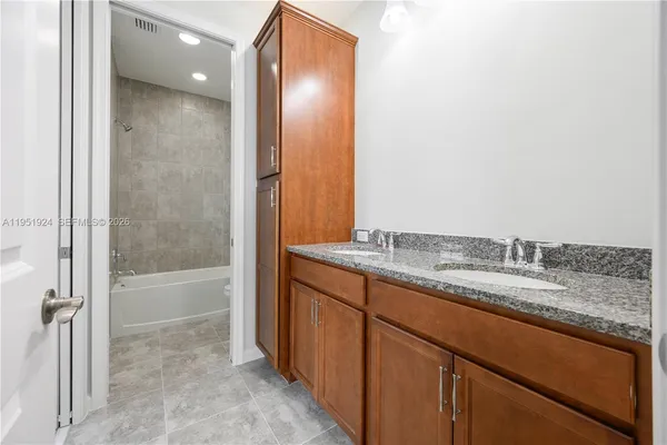 a bathroom with a granite countertop sink and a mirror