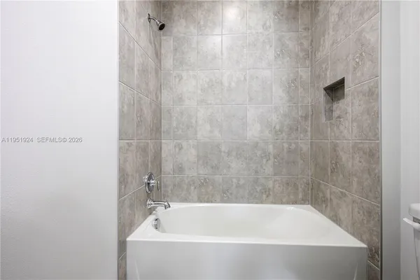 a white bath tub sitting next to a white sink and vanity