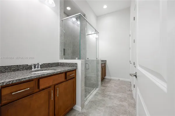 a bathroom with a granite countertop sink and a mirror