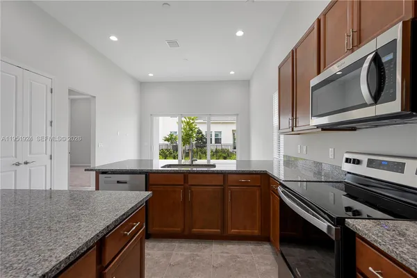 a kitchen with stainless steel appliances granite countertop a sink and stove top oven