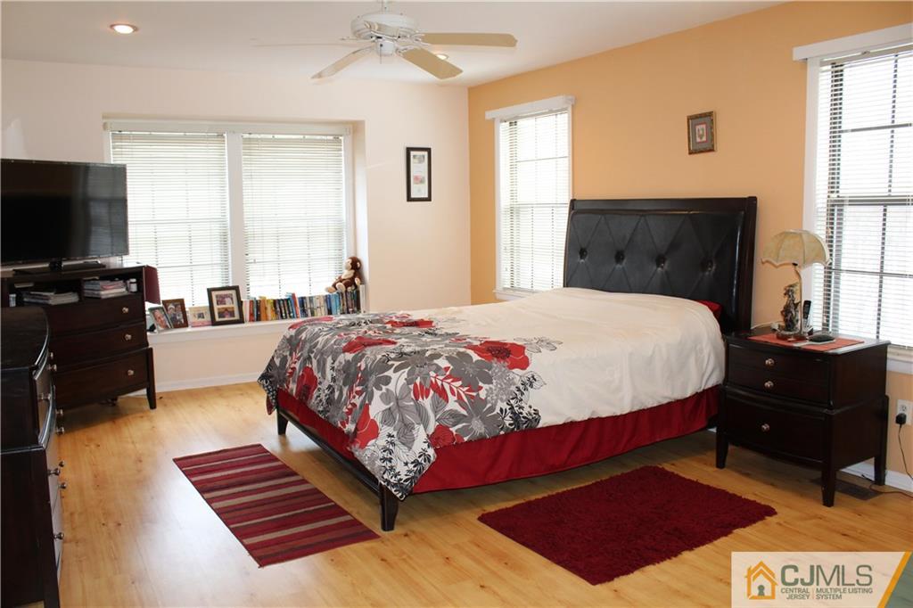 4901 Stonehedge Road, Unit 4901 Edison, NJ 08820 - Photo 13 of 22 a bedroom with a bed and wooden floor