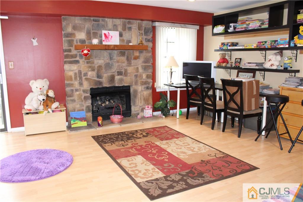 4901 Stonehedge Road, Unit 4901 Edison, NJ 08820 - Photo 20 of 22 a living room with stainless steel appliances furniture a rug and a fireplace