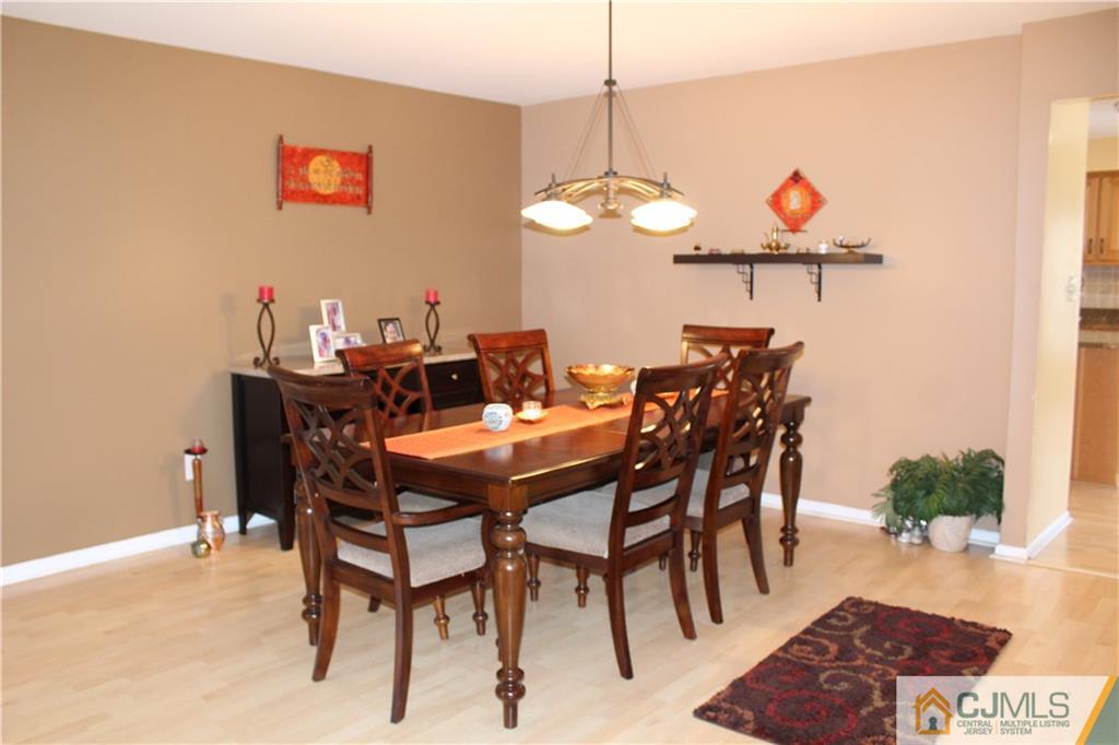 4901 Stonehedge Road, Unit 4901 Edison, NJ 08820 - Photo 5 of 22 a view of a dining room and livingroom furniture wooden floor a rug and a chandelier