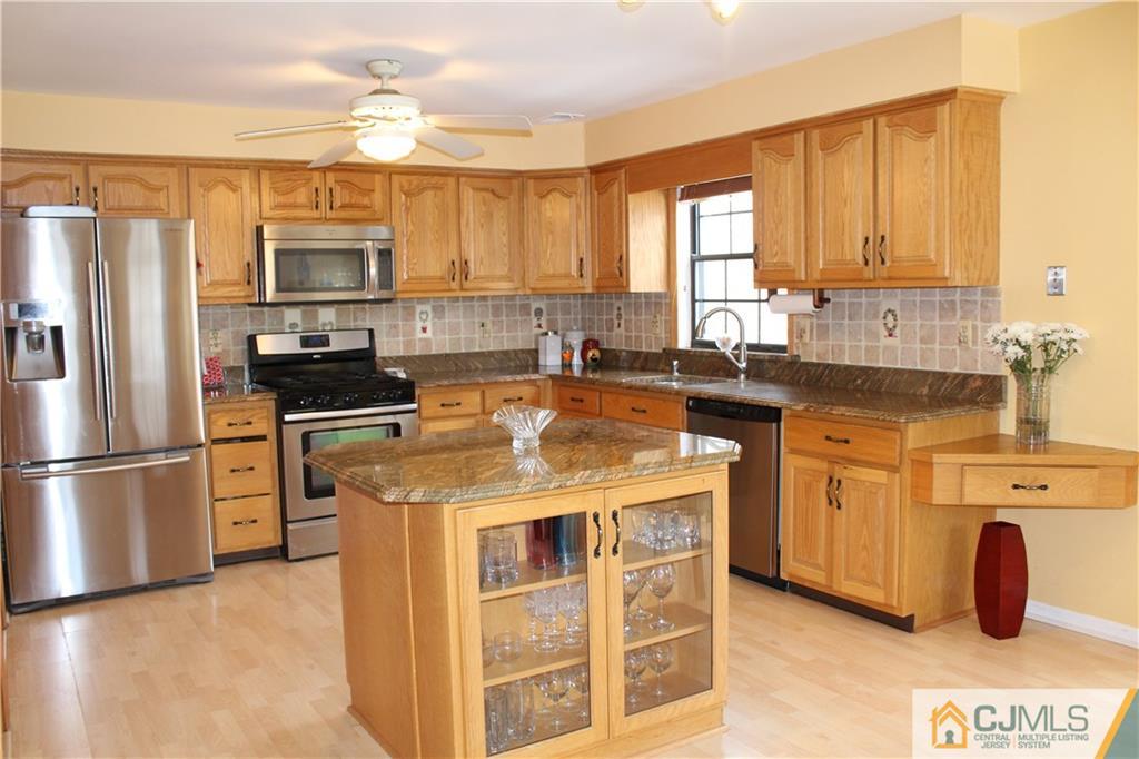 4901 Stonehedge Road, Unit 4901 Edison, NJ 08820 - Photo 6 of 22 a kitchen with stainless steel appliances granite countertop a refrigerator a stove a sink and white cabinets