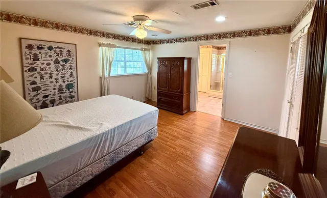 a bedroom with a bed and a mirror on the dresser