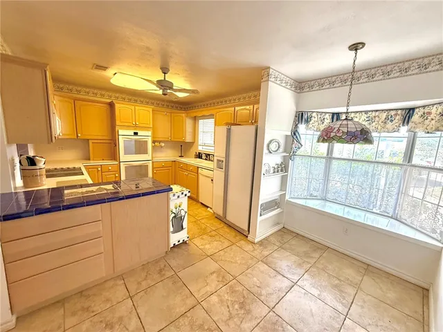 a large kitchen with kitchen island granite countertop a large window and a counter top space