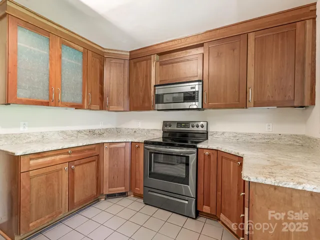 a kitchen with stainless steel appliances granite countertop a stove microwave and refrigerator