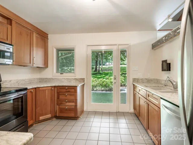 a kitchen with stainless steel appliances granite countertop a stove a sink and a microwave