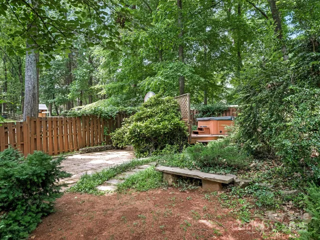 a view of a backyard with a bench and trees