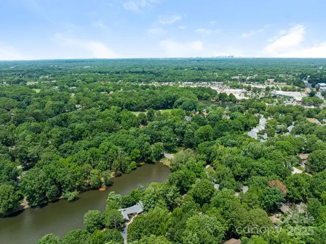 an aerial view of residential houses with outdoor space and trees