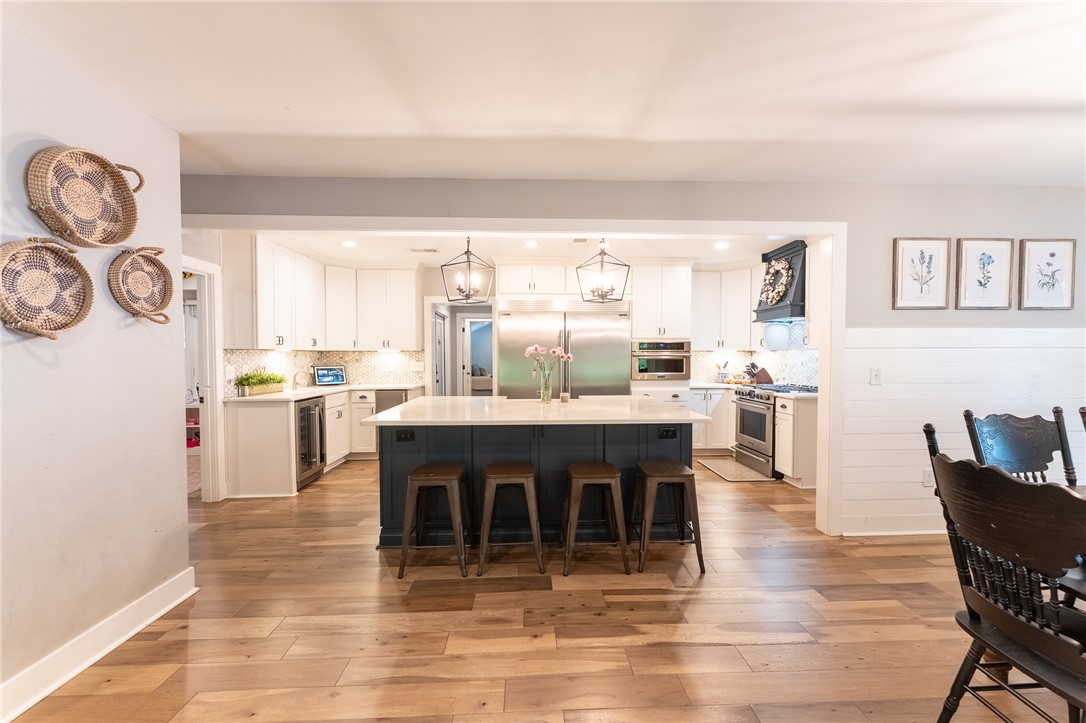 103 Riggs Drive Clemson, SC 29631 - Photo 5 of 50 An inviting kitchen with a spacious island, premium appliances, and warm hardwood flooring.
