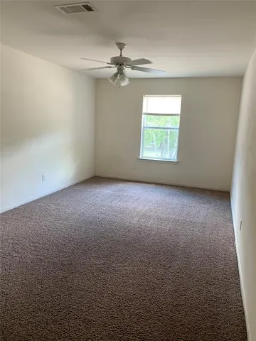 an empty room with a window and a fan