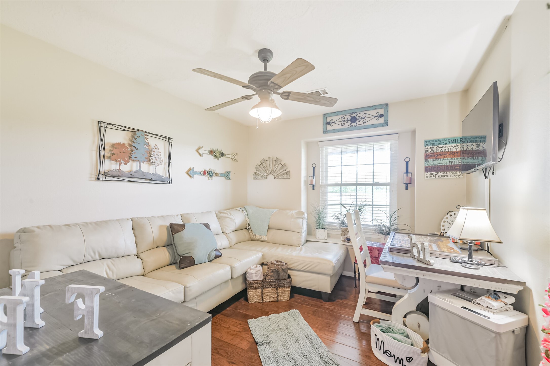 307 West Hufsmith Road Tomball, TX 77375 - Photo 22 of 44 Cozy living area featuring a plush corner sectional, stylish decor, and a bright window nook with a charming workspace.
