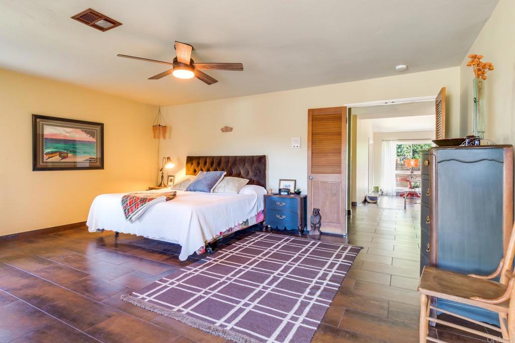 1106 Big Oak Ranch Road Fallbrook, CA 92028 - Photo 23 of 53 a bedroom with a large bed and a chandelier