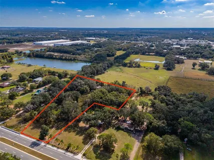 an aerial view of residential houses with outdoor space and lake view