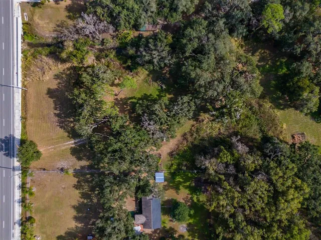 an aerial view of residential houses with outdoor space and trees