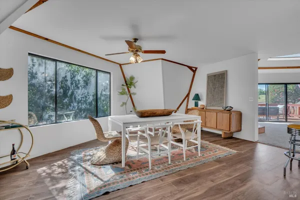 a living room with furniture a wooden floor and a large window