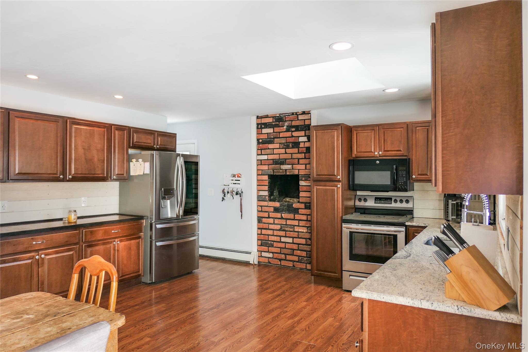 84 Bieselin Road Bellport, NY 11713 - Photo 6 of 20 a kitchen with stainless steel appliances a refrigerator and wooden floor