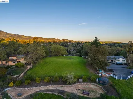 an aerial view of lake residential house with swimming pool and mountain view