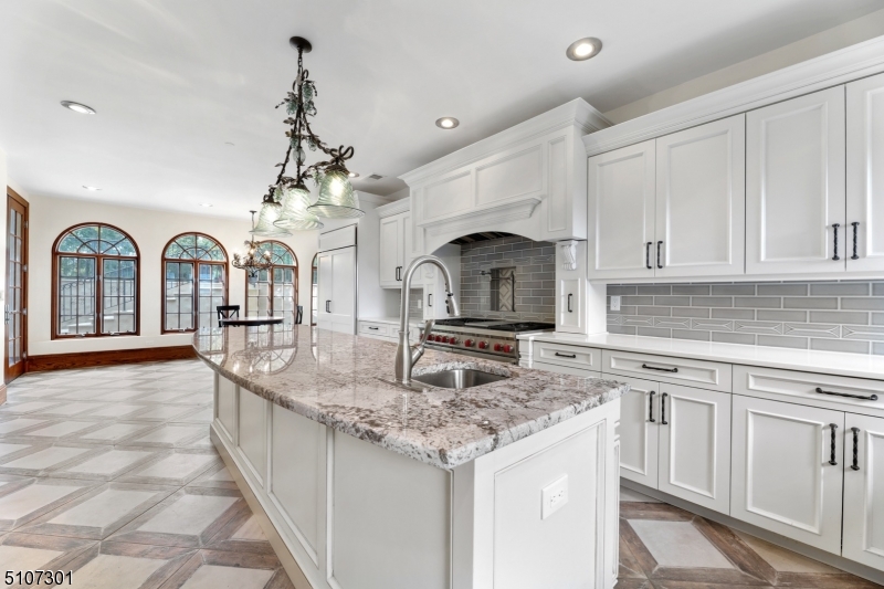 50 Rock Spring Road West Orange, NJ 07052 - Photo 18 of 37 a kitchen with stainless steel appliances granite countertop a sink a stove cabinets and living room view