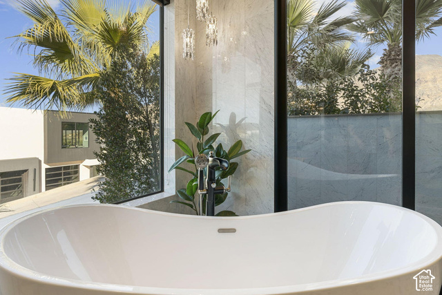 3652 South Cypress Road Hurricane, UT 84737 - Photo 46 of 81 Freestanding soaking tub with a modern floor-mounted faucet, large format tile wall, and expansive window with black framing