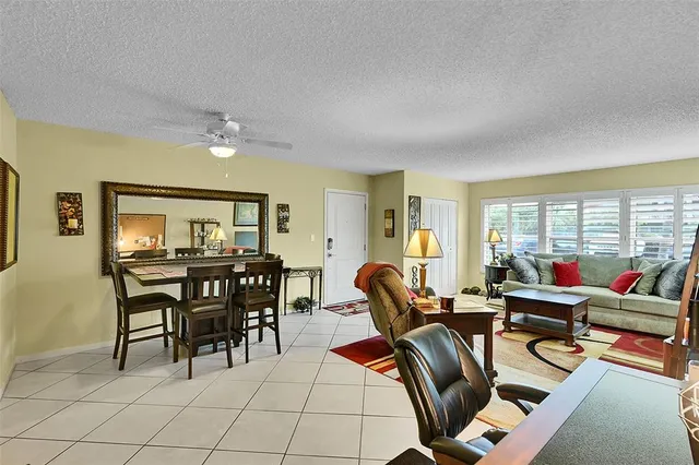 a living room with furniture a dining table and chairs next to a window
