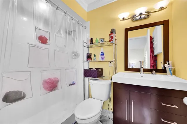 a bathroom with a sink vanity mirror and toilet
