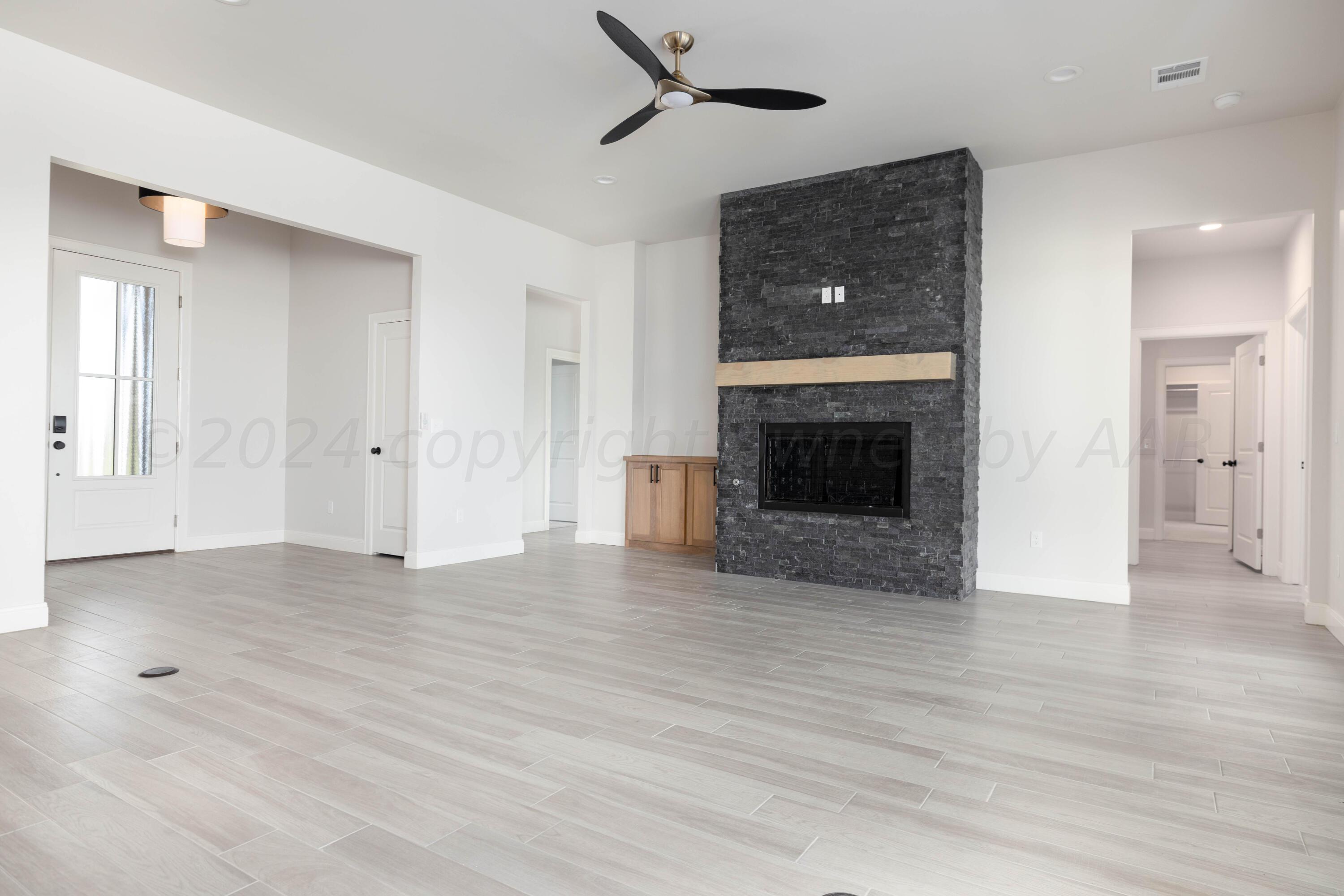 10201 Cactus Flower Road Amarillo, TX 79119 - Photo 2 of 48 an empty room with wooden floor a fireplace and windows