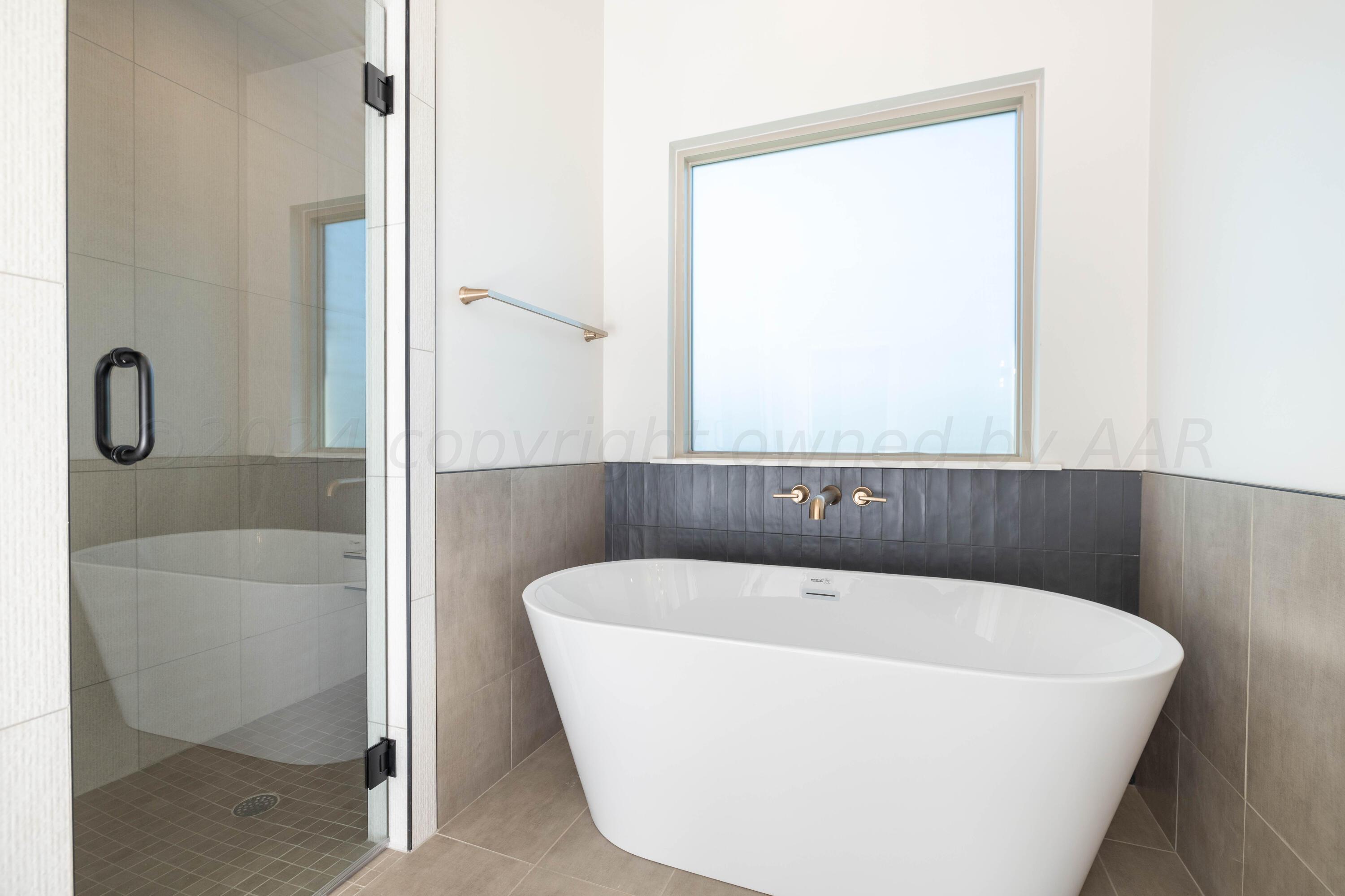 10201 Cactus Flower Road Amarillo, TX 79119 - Photo 31 of 48 a white bath tub sitting next to a small window