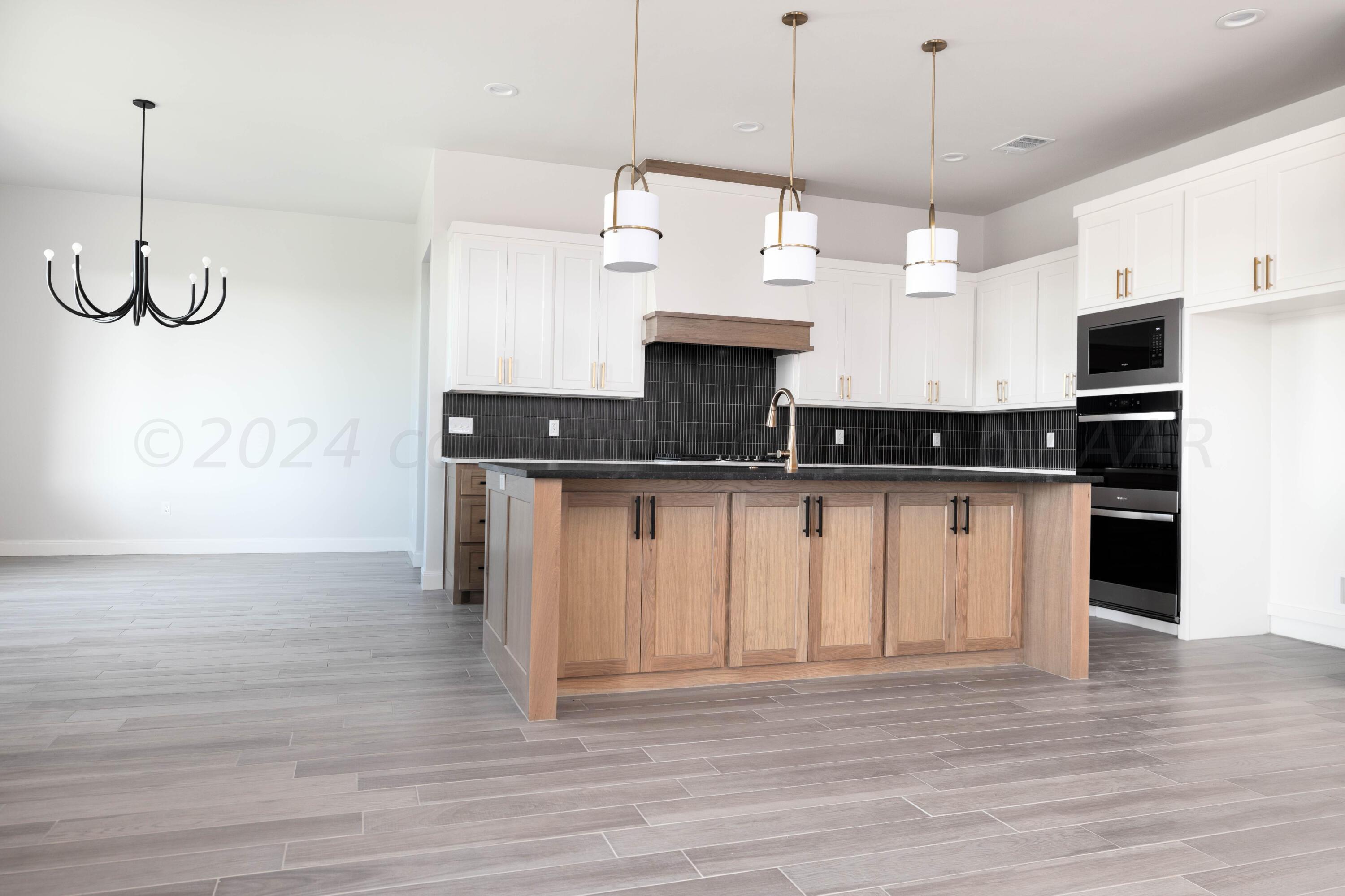 10201 Cactus Flower Road Amarillo, TX 79119 - Photo 4 of 48 a kitchen with stainless steel appliances granite countertop a sink a stove and a wooden floor