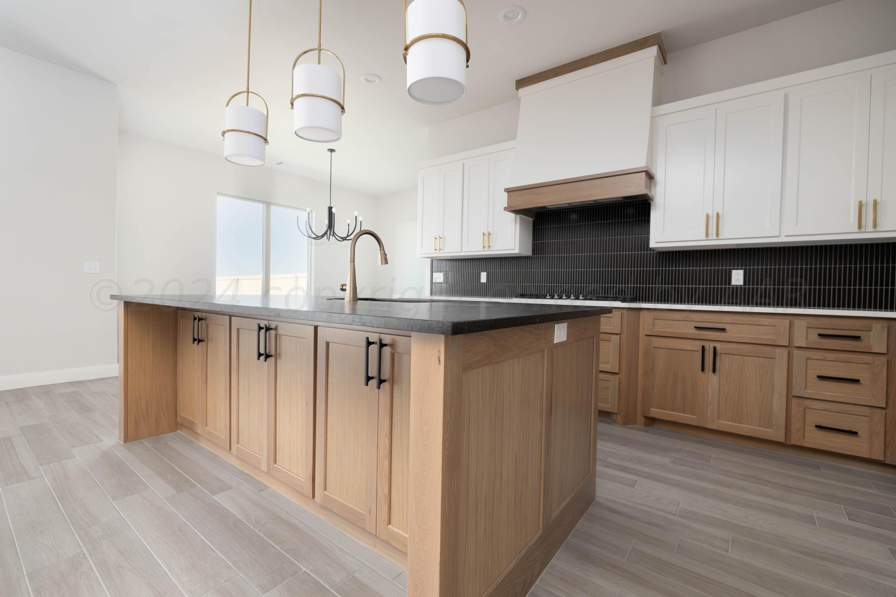 10201 Cactus Flower Road Amarillo, TX 79119 - Photo 6 of 48 a kitchen with kitchen island granite countertop a sink cabinets and wooden floor