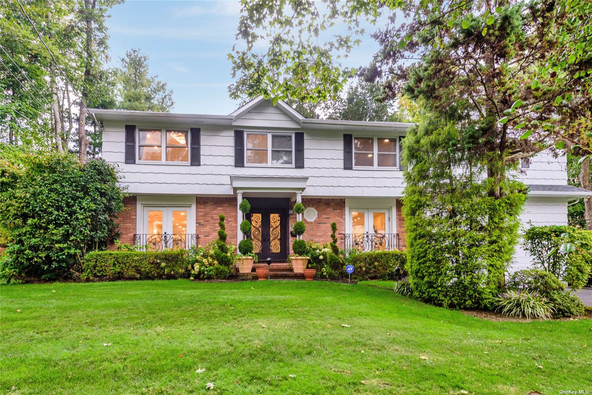 79 Beach Road Great Neck, NY 11023 - Photo 1 of 1 a front view of a house with a garden and yard