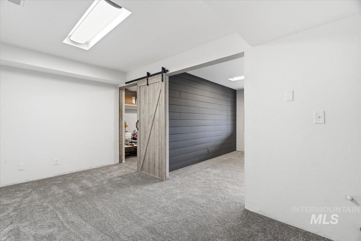 7771 Elmore Road Fruitland, ID 83619 - Photo 23 of 48 Basement with light colored carpet and a barn door