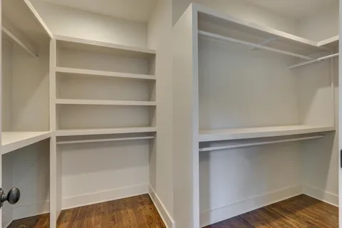an empty room with wooden floor and entrance
