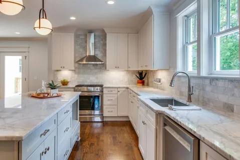a kitchen with granite countertop a sink stainless steel appliances and cabinets