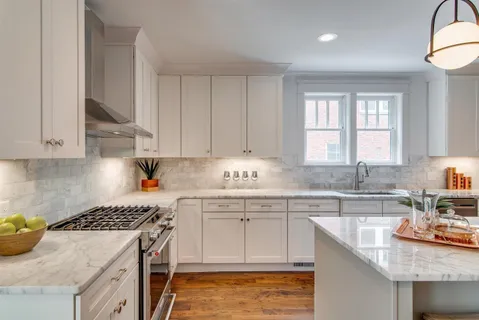 a kitchen with granite countertop a sink a stove and cabinets