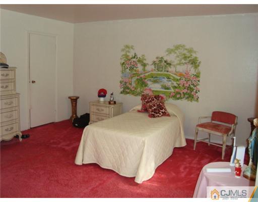 12 Hilltop Road Edison, NJ 08820 - Photo 11 of 23 a bedroom with a bed and a chair