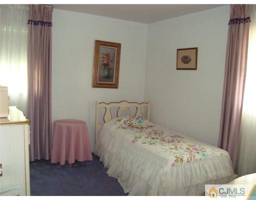 12 Hilltop Road Edison, NJ 08820 - Photo 13 of 23 a bed sitting in a bedroom next to a window and a chair