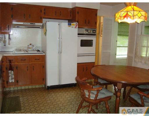 12 Hilltop Road Edison, NJ 08820 - Photo 7 of 23 a kitchen with stainless steel appliances kitchen island granite countertop a table chairs and a refrigerator