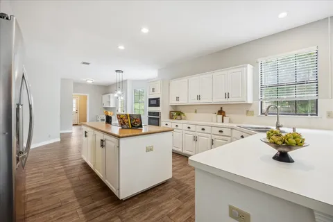 a kitchen with white cabinets and appliances