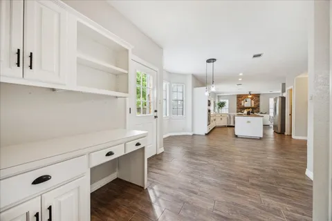 a view of empty room with wooden floor and window
