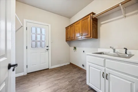 a kitchen with a sink cabinets and a wooden floor