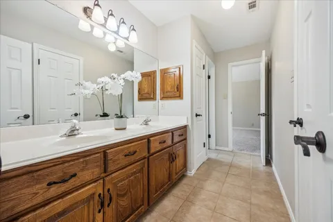 a spacious bathroom with a double vanity sink a large mirror a shower and a bathtub