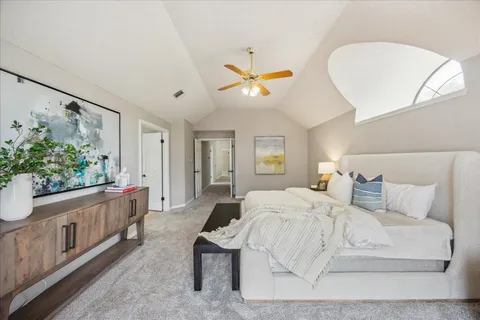 a spacious bedroom with a bed and a chandelier