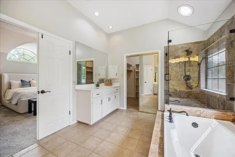 a bathroom with a tub sink and mirror