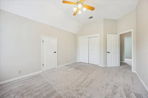 a view of an empty room with a ceiling fan