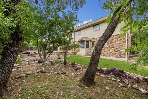 a view of a house with backyard and a tree